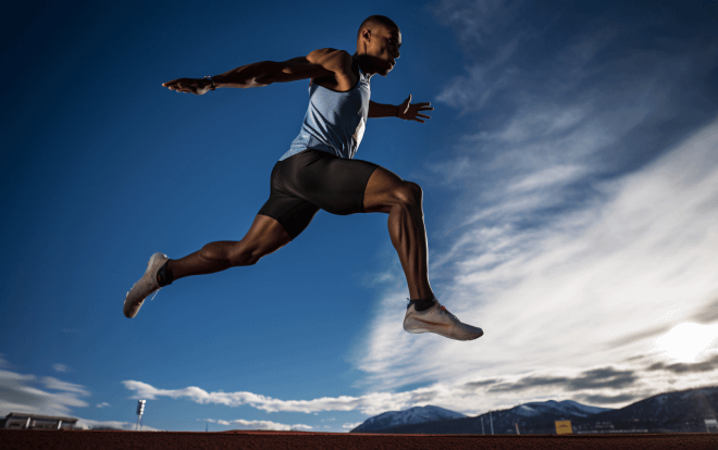 A muscular athlete taking a powerful leap into the air against a backdrop of a clear blue sky and distant mountains, embodying the spirit of 'Take the leap now' with determination and strength.