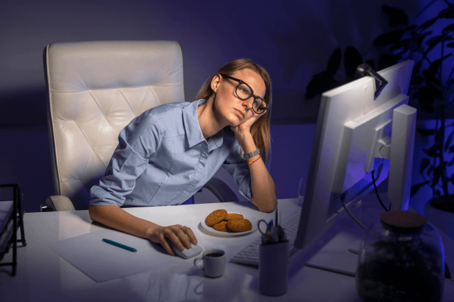 Exhausted woman at computer late at night, reflecting the hidden emotional sacrifices entrepreneurs face.