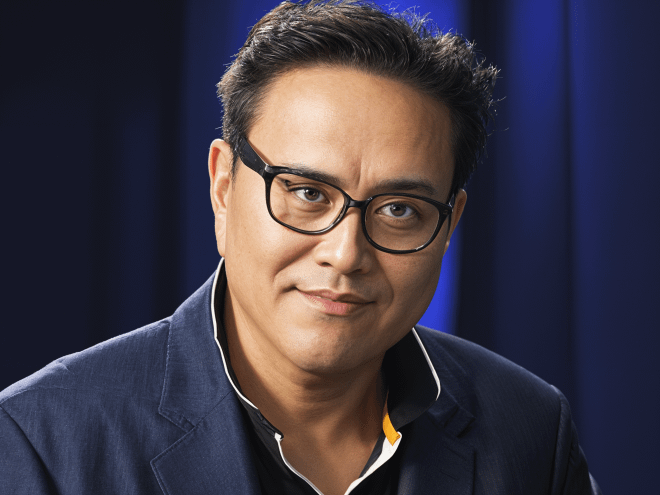 A portrait of Robert Kiyosaki, the author of "Rich Dad Poor Dad," wearing glasses and a dark suit, set against a deep blue background. This image accompanies an article featuring 43 inspiring quotes from Robert Kiyosaki, highlighting his wisdom and motivational insights for entrepreneurs and investors.